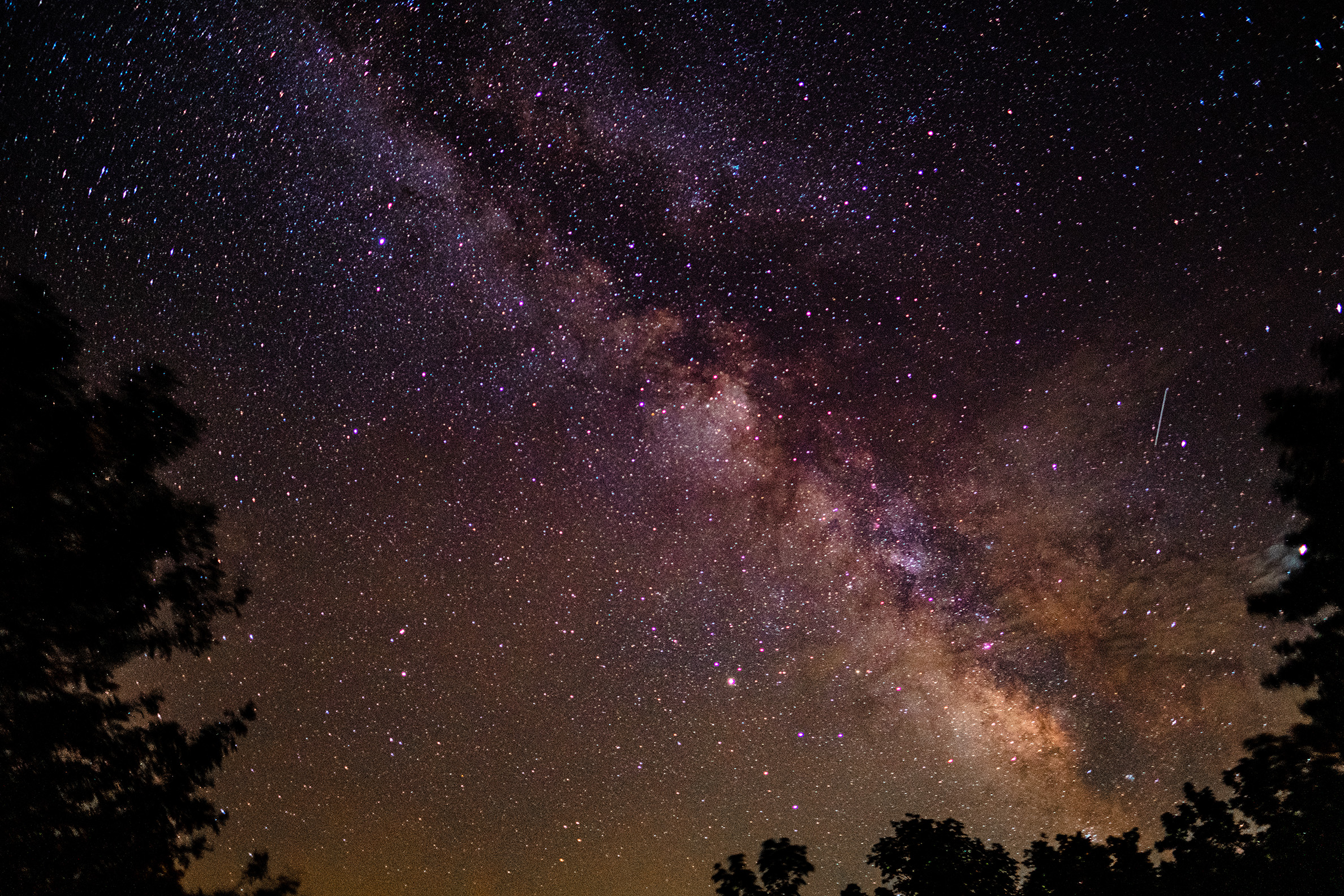 A photograph of the night sky showing thousands of stars and a brighter band across the center that is the Milky Way.