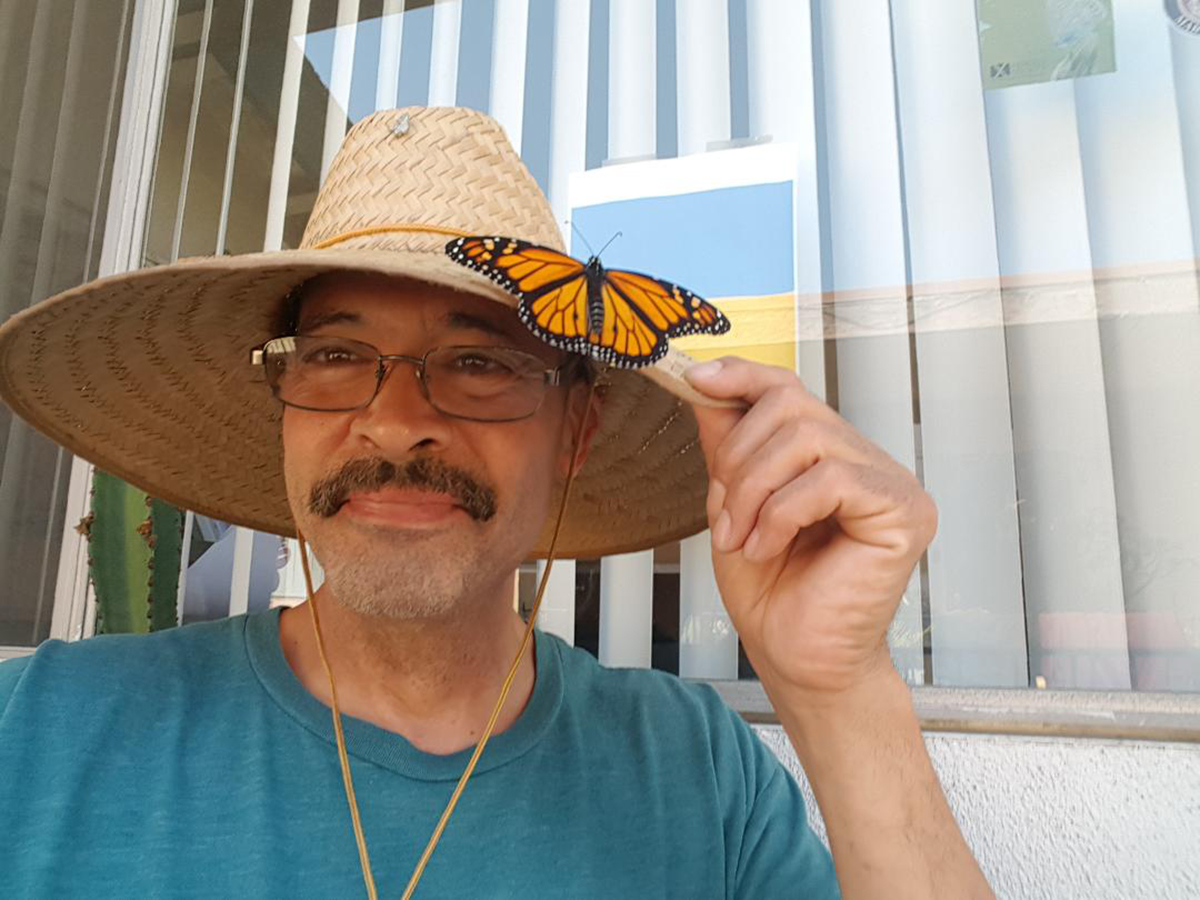 Augustin with resting monarch butterfly on his sun hat