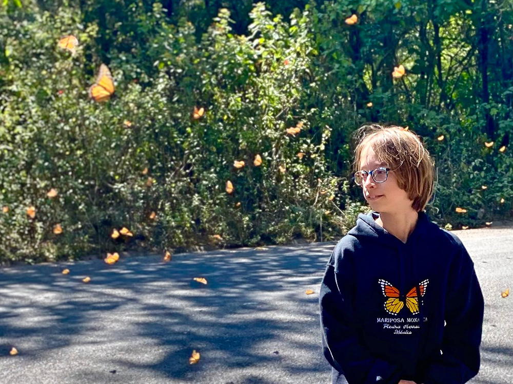 Noah Raven surrounded by flying monarch butterflies