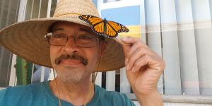 Augustin with resting monarch butterfly on his sun hat