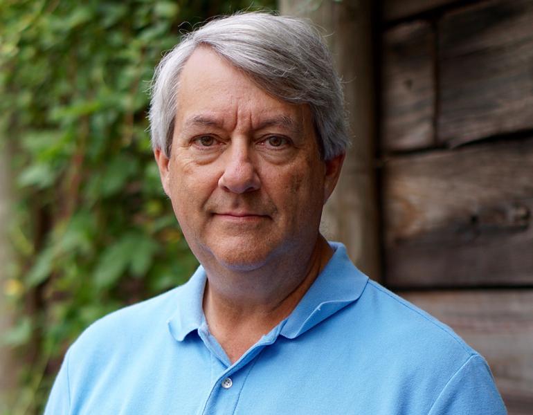 Ted Burk, an older white man with grey hair, smiling gently
