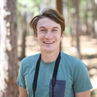 Michael Trier in a forest with binoculars around his neck